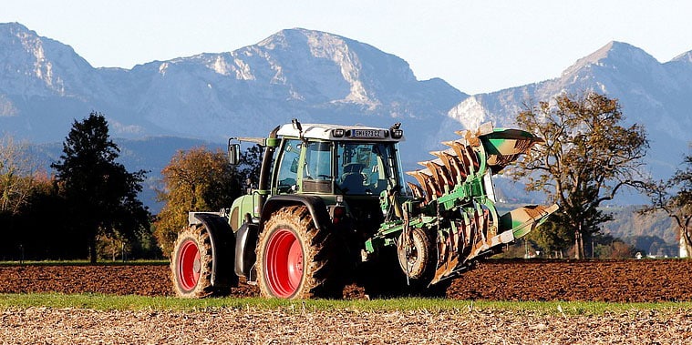 Tracteur agricole attelé à une charrue réversible portée sur le relevage arrière